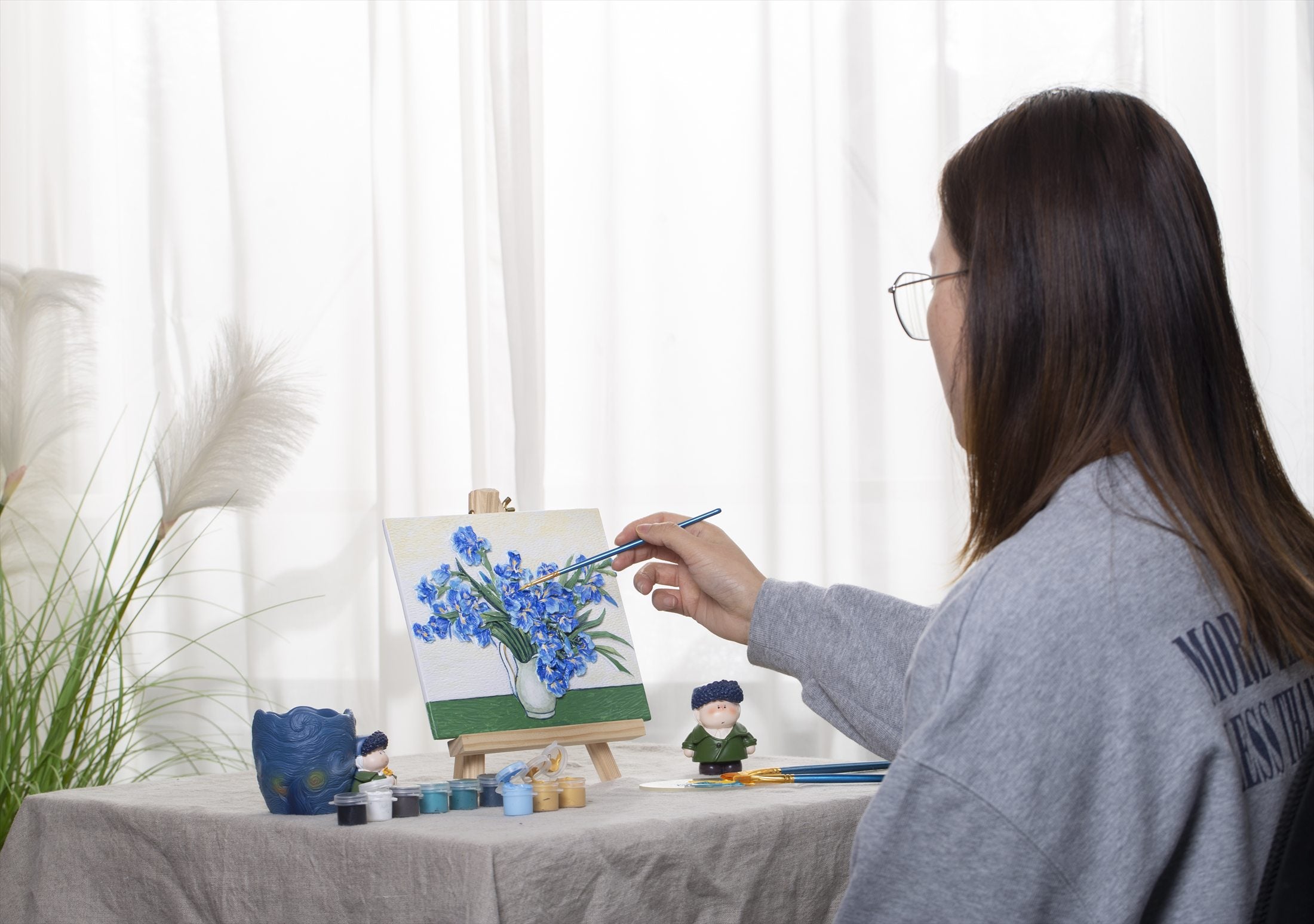 A maker painting a Relife relief artwork at a prepared table